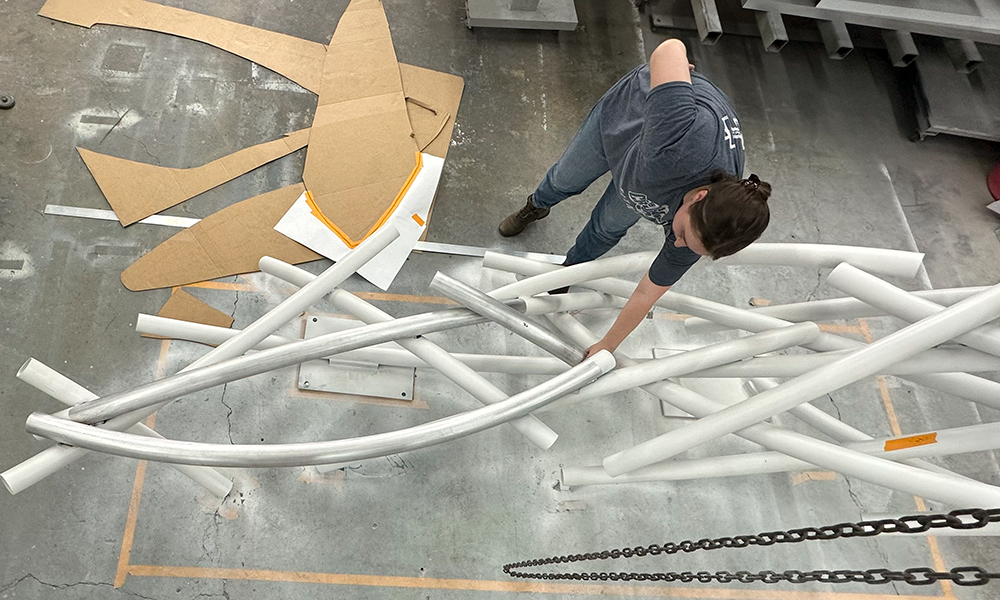 Danielle Sisson placing pieces of the sculpture on the floor.