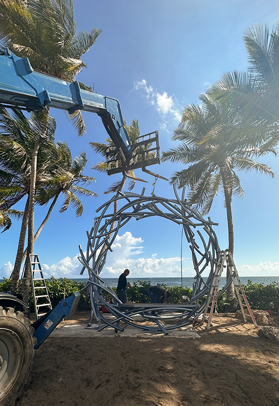 A forklift and the crew putting the sculpture together.