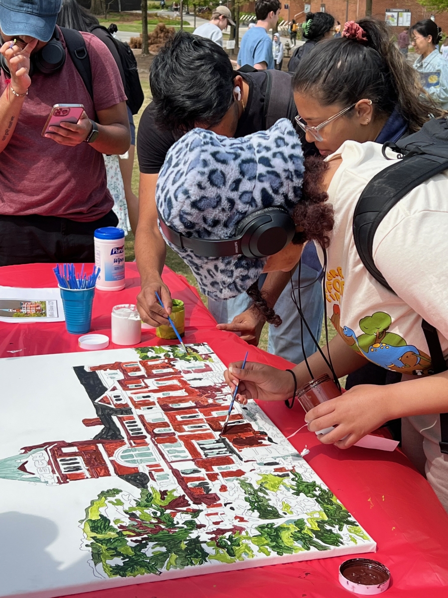 Students painting tech tower on canvas