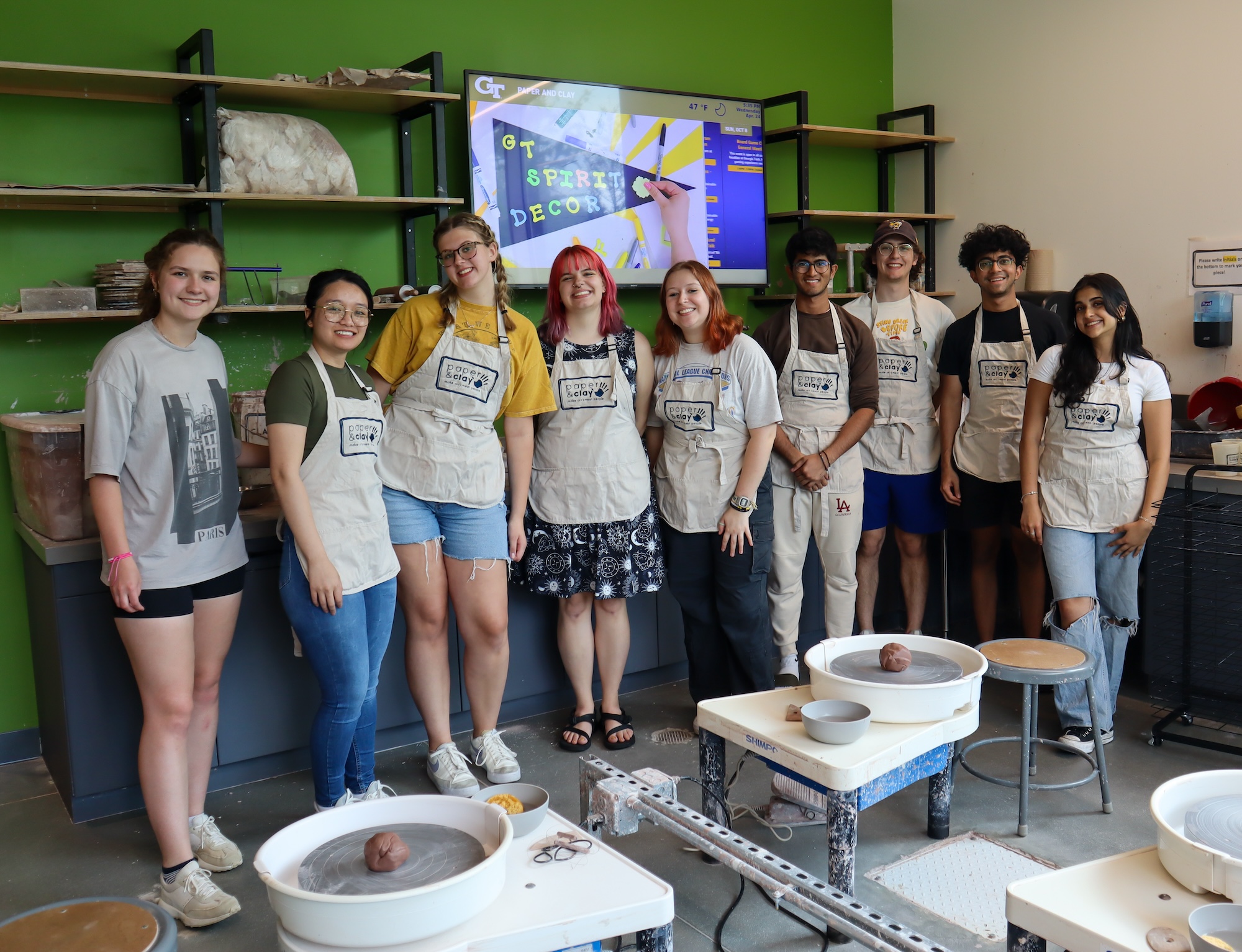 Group of students in arts environment with green wall in background