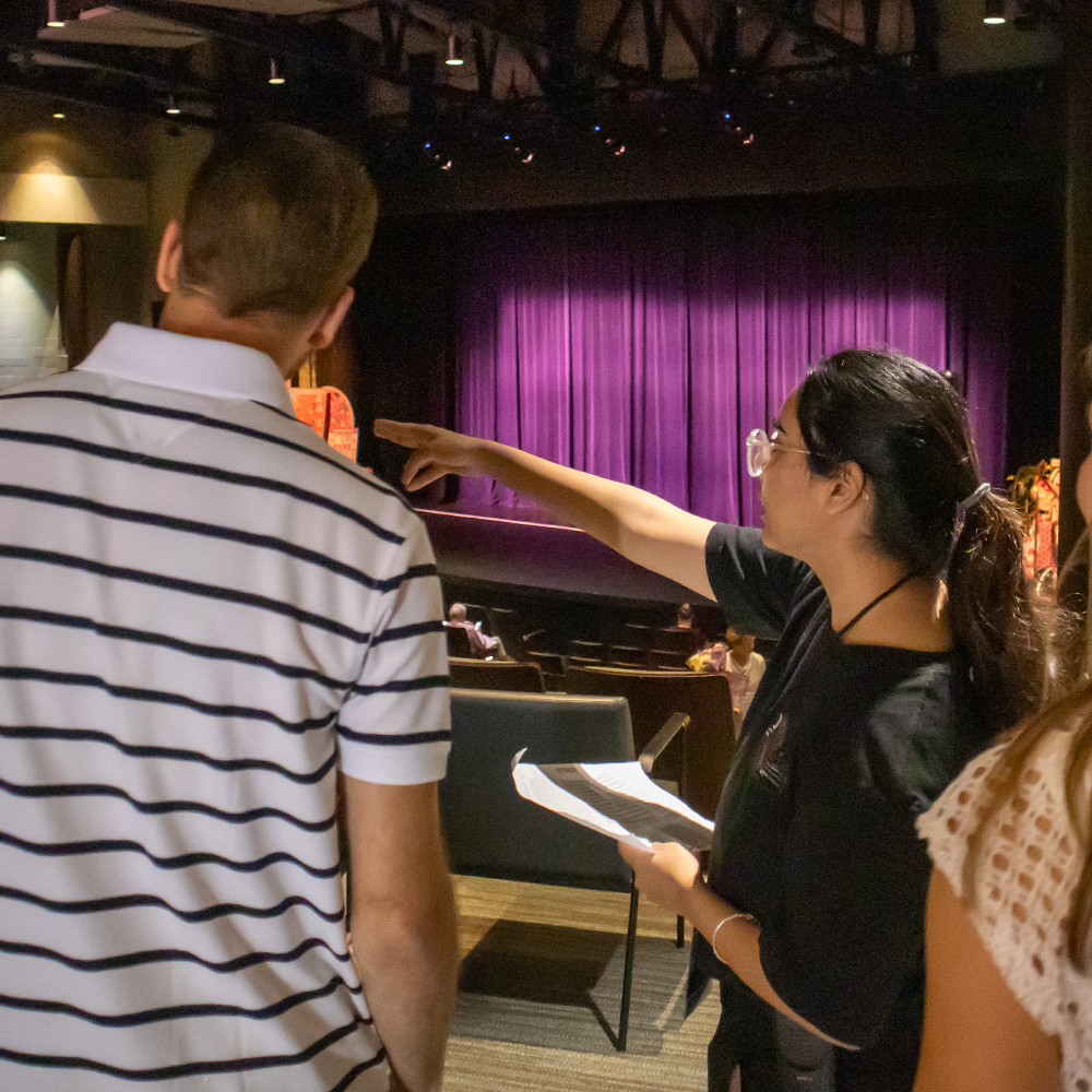 Student usher guiding visitor to seat