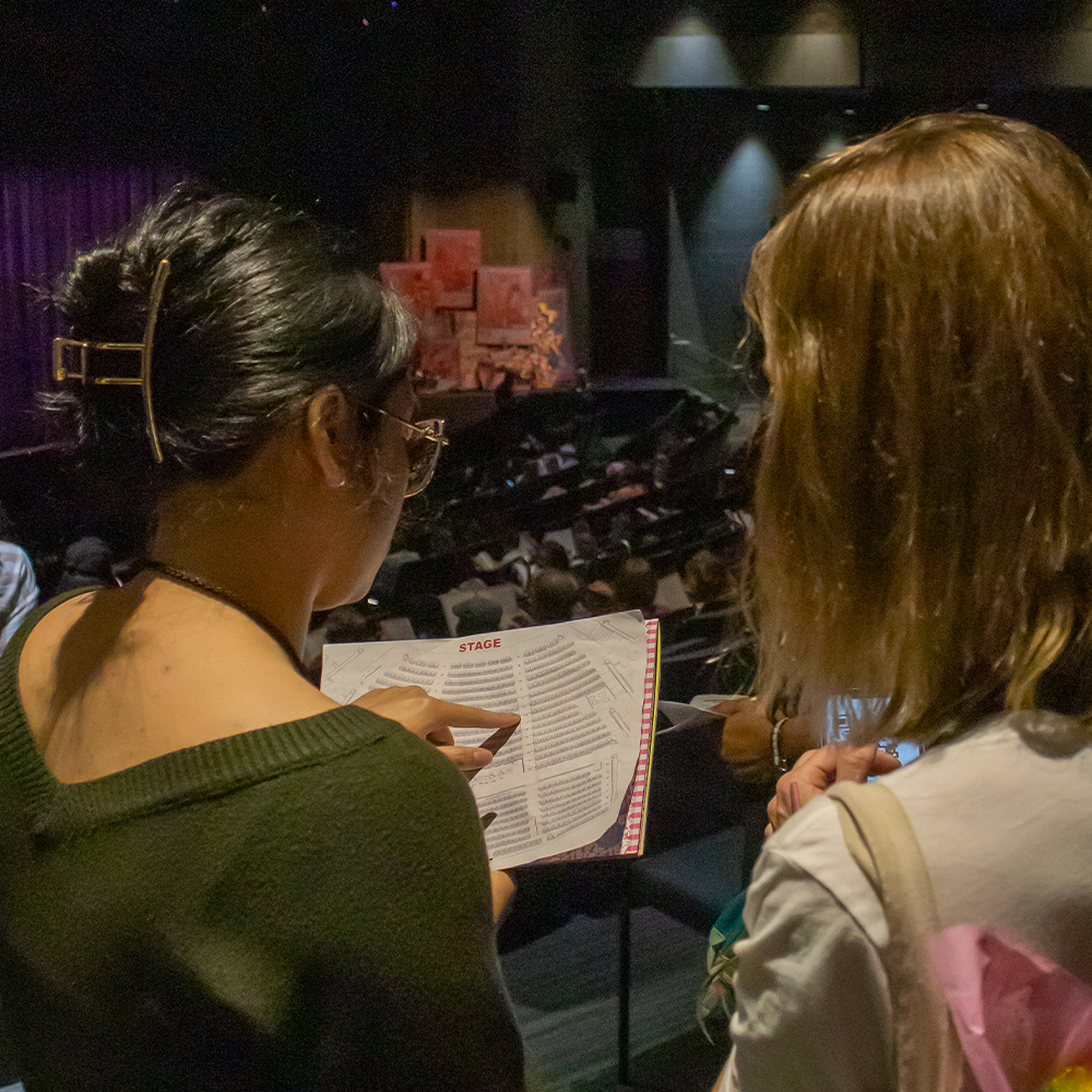 Student usher guiding visitor to seat