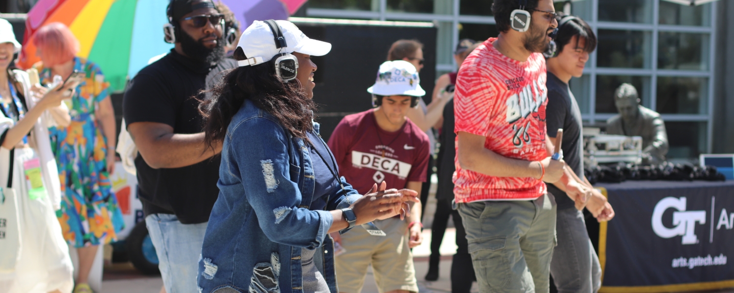 People dancing while wearing headphones during a Silent Disco event with DJ 2-Smooth.