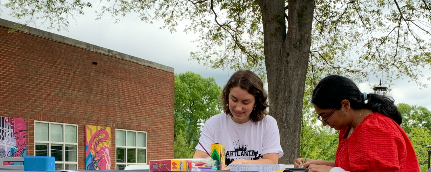 Students sitting at a table making art.