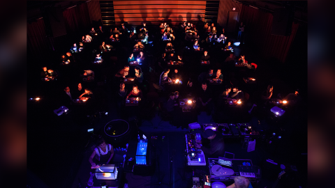 In a darkened theater there are 50 illuminated seating areas each with their own turntable.