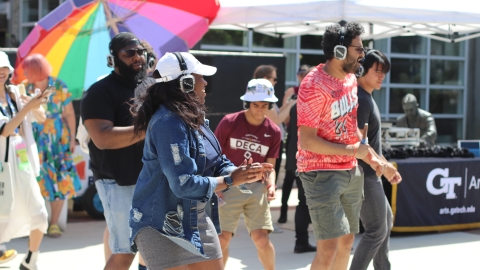 People dancing while wearing headphones during a Silent Disco event with DJ 2-Smooth.