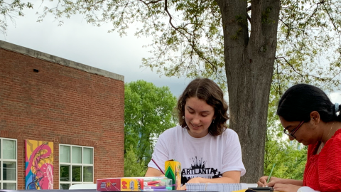 Students sitting at a table making art.