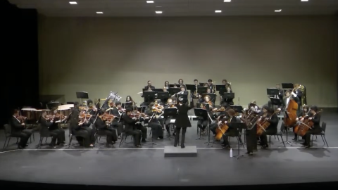 Group of musicians gathered on stage playing various instruments