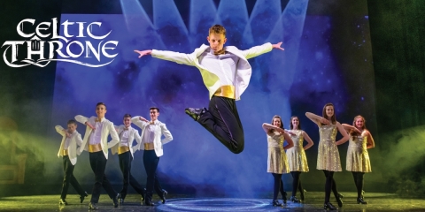 several dancers on stage with one dancer jumping in air