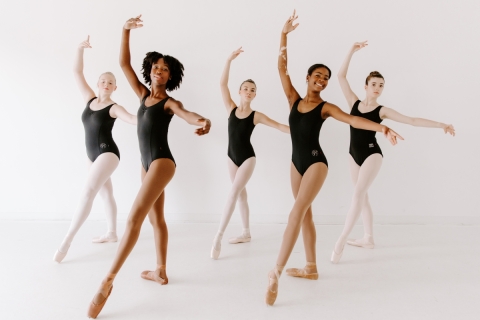 Five dancers in black leotards 