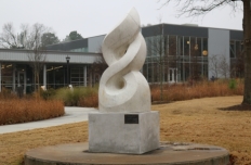 Smooth white marble, only lightly veined, sculpted as an abstract rendering of the olympic flame.