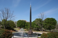 80 foot tall stainless steel spire based in a pool of water with fountains.