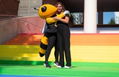 Buzz and a woman hug while standing on the Pride Stairs.