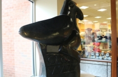 smooth black Springstone Serpentine sculpted in shape of a bird perched on a pedestal inscribed with geometric shapes