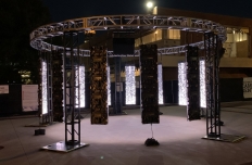 12 LED panels, each 8 feet tall, are hanging from a truss arranged facing eachother in a circle.