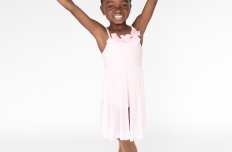 One young girl in a pink leotard and dance skirt holding a bough of flowers over her head