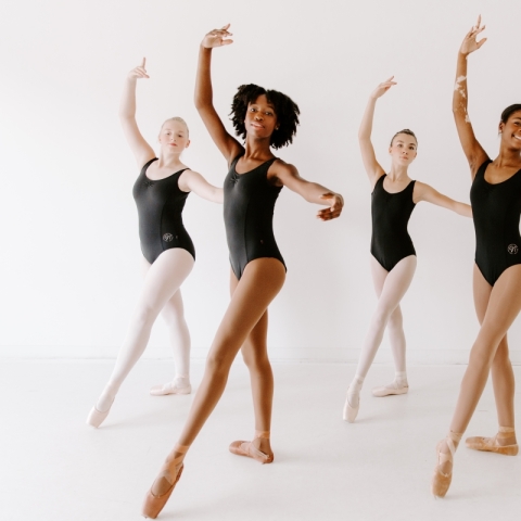 Five dancers in black leotards 